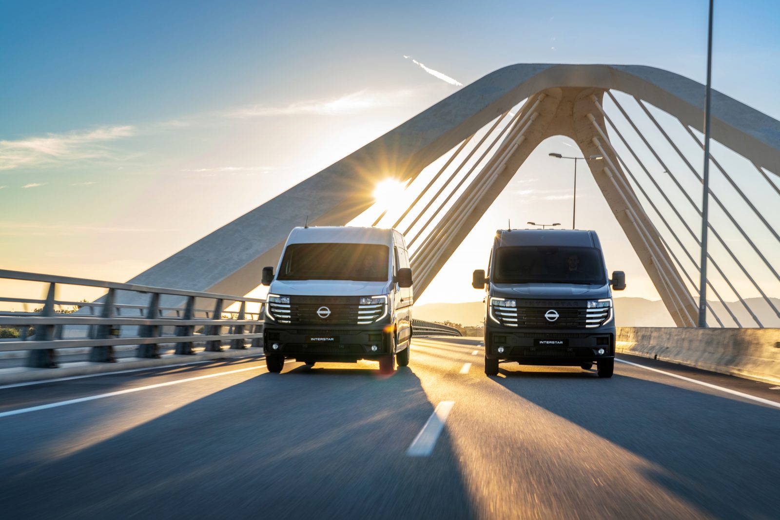 2 nissan interstar electric vans driving on bridge 