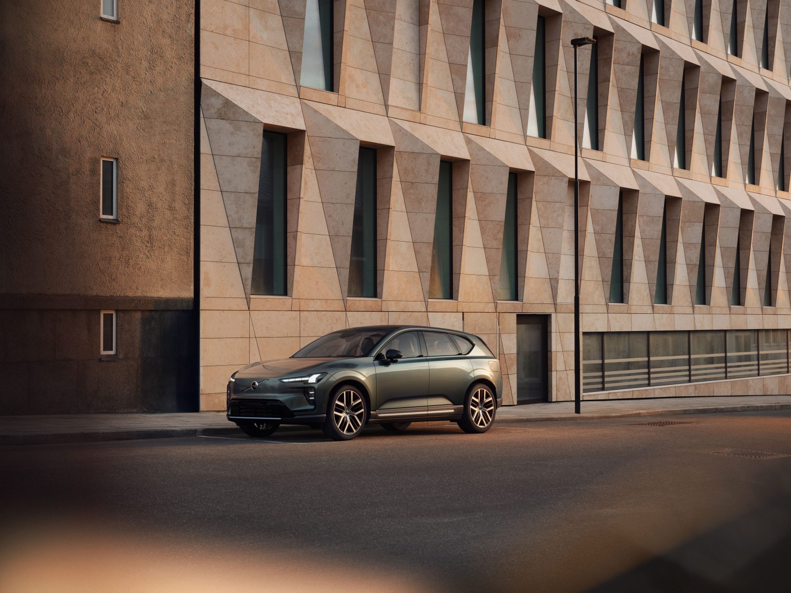 Volvo ex60 electric car on street in front of modern building