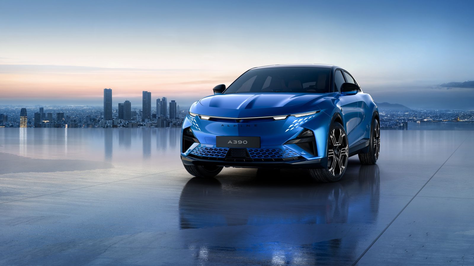 Alpine A390 electric car in blue with city skyline in the distance