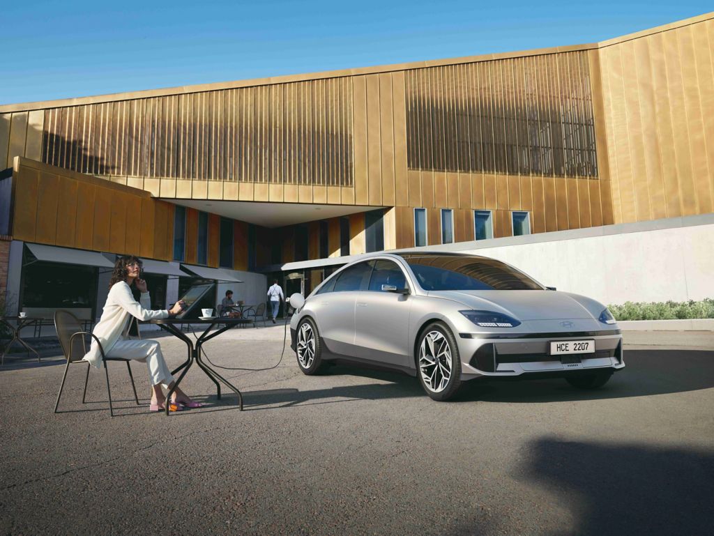 Hyundai IONIQ 6 First Edition charging with woman sat at a table