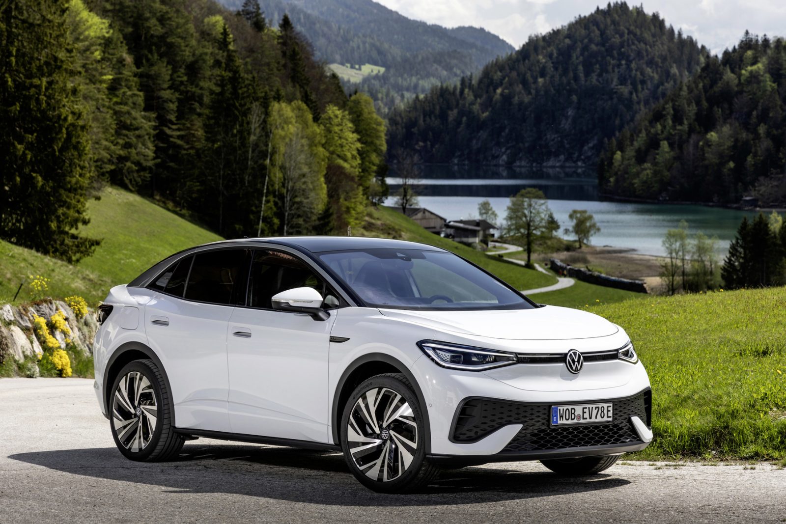 Volkswagen ID5 on road with hills river sky scenery