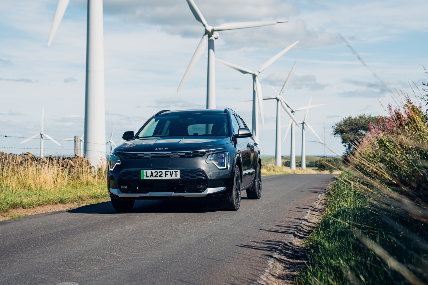 Electric car with wind turbines in the background