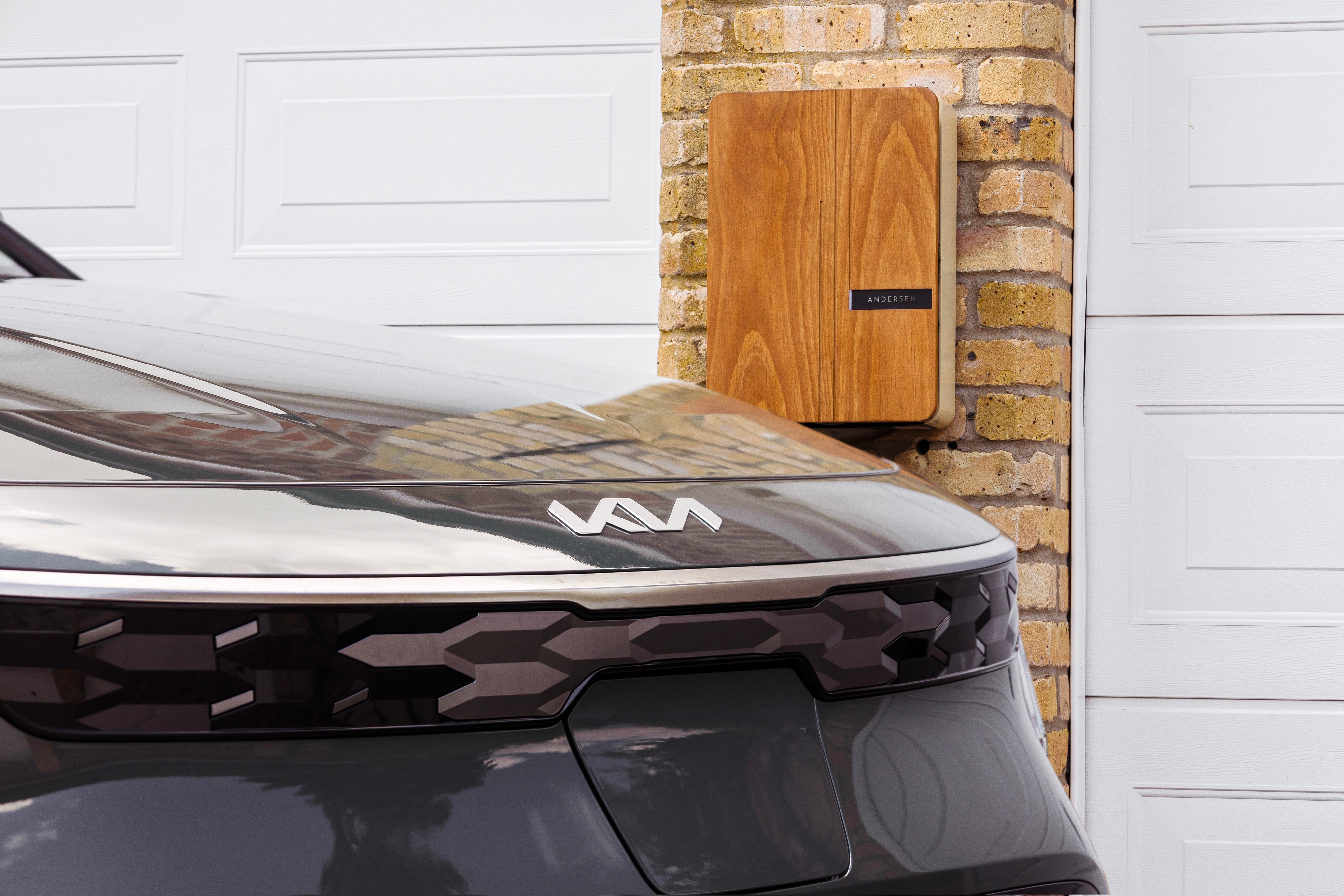 car on home driveway in front of charger