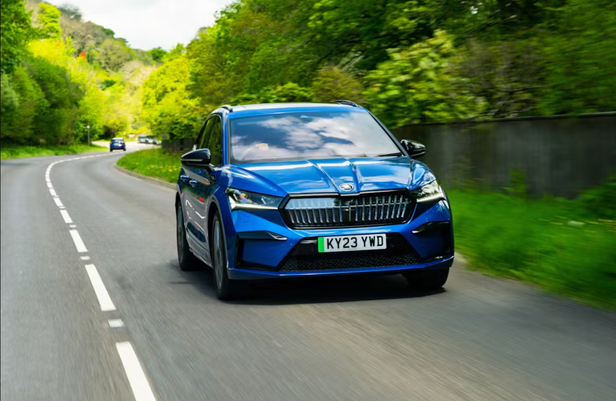 Blue skoda electric car driving in forest